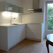 Küche mit Hängeregal und Rückwandplatte weiß lackiert